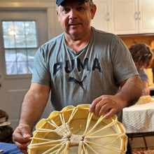 Load image into Gallery viewer, Todd Labrador standing in a kitchen showing the back of one of his handmade drums.
