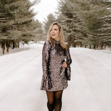Load image into Gallery viewer, Woman in a sequin dress walking on a snow-covered road with trees in the background
