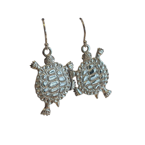 Pair of silver turtle-shaped earrings on a light gray background